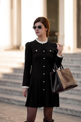 a lady in a black pleated mini dress with a white ruffle collar